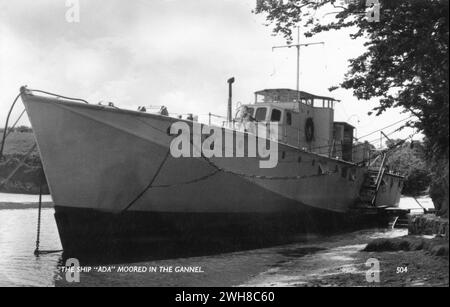 Newquay, Devon. Anni '1960 - Una cartolina fotografica d'epoca dal titolo "The Ship 'Ada' ormeggiata nel Gannel", raffigurante una nave dismessa del periodo della seconda guerra mondiale, ex-Royal Navy Fairmile Type D Motor Torpedo Boat, denominata "Ada". È ormeggiata sul fiume Gannel, vicino a Newquay, Devon. Foto Stock