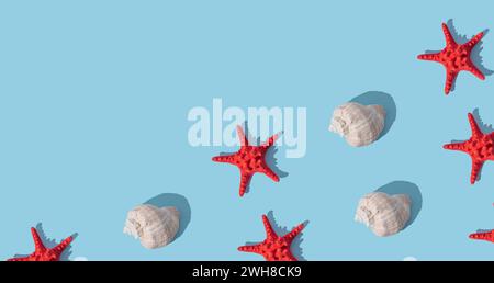 Trendy sunlight summer pattern made with sea shells and red starfish on light blue background. Minimal summer concept. Creative sea shell and starfish Foto Stock