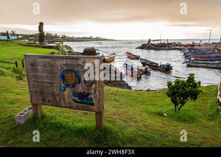 Le colorate barche da pesca in legno sono attaccate alle corde nel porto di Hanga Roa a Rapa Nui durante il tramonto, sull'Isola di Pasqua Foto Stock