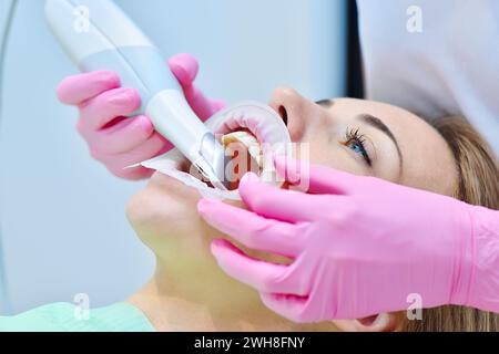 Donna dentista che utilizza uno scanner intraorale dentale durante l'esame dei denti del paziente in clinica odontoiatrica. Scansione intraorale con macchina di scansione. Chiudere u Foto Stock