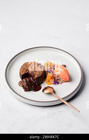 Fondente al cioccolato caldo, frammenti di agrumi Cointreau, neve gianduja, sorbetto all'arancia rossa Foto Stock