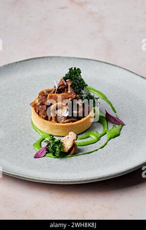 Funghi forestali, tartufo nero e crostata di carciofi di Gerusalemme, crema di spinaci, patatine di cavolo Foto Stock