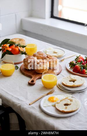 Colazione Tablescape con pasticcini, succo d'arancia e frutta Foto Stock