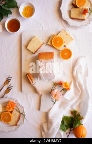 Torta madeira all'arancia servita con sciroppo e scorza d'arancia. Piano con tavolo da tè pomeridiano. Foto Stock