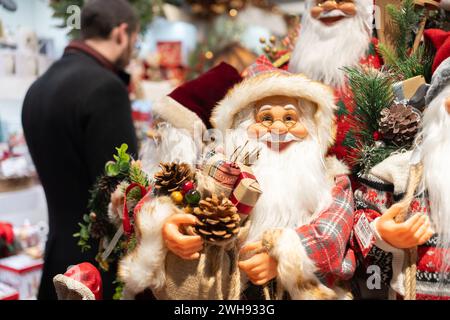 Giocattoli di Babbo Natale al mercato durante le vacanze natalizie, contribuendo alle tradizioni e alle celebrazioni invernali. Le decorazioni natalizie di Babbo Natale adornano i centri commerciali. Foto Stock