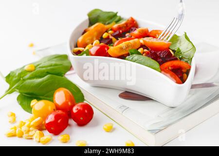 insalata con verdure fresche in un recipiente su sfondo bianco. Foto Stock