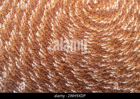 Sfondo a trama astratta macro di un tovagliolo in tessuto dal design circolare nei colori marrone e beige Foto Stock