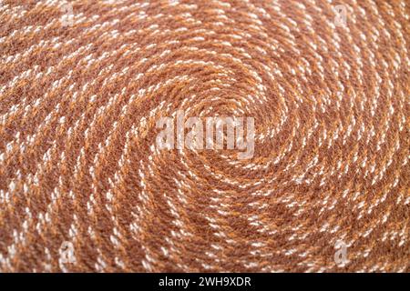 Sfondo a trama astratta macro di un tovagliolo in tessuto dal design circolare nei colori marrone e beige Foto Stock