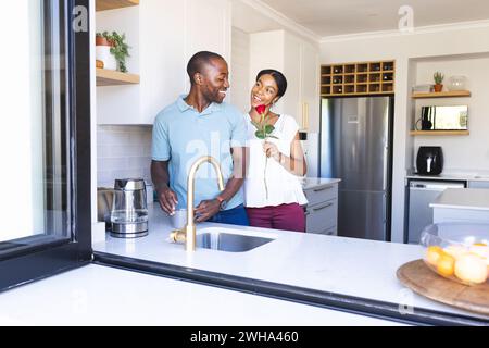 La coppia birazziale si diverte a divertirsi in cucina Foto Stock