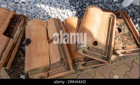 tegole rotte della casa dopo una tempesta di grandine con buchi e impatti di grandi grandine Foto Stock