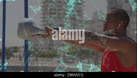 Immagine di una rete di comunicazione illuminante sull'atleta maschile che si esercita con il kettlebell in città Foto Stock