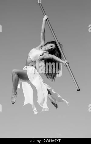 Aerialist professionista che si esibisce su un palo da ballo aereo all'aperto Foto Stock