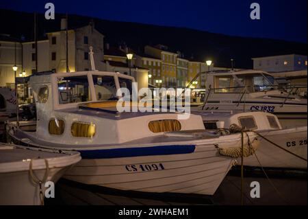 Cherso, Croazia - 24 ottobre 2022: Barche nel porto di Cherso (Croazia) dopo il tramonto Foto Stock