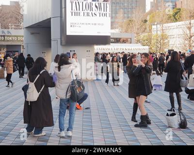 TOKYO, GIAPPONE - 7 febbraio 2024: Fan di Taylor Swift davanti a un grande schermo di fronte al Tokyo Dome, dove le persone sono riunite prima di un concerto Swift. Foto Stock