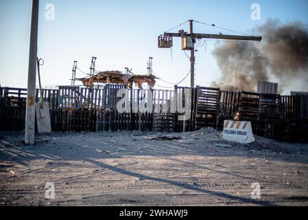 Barricate fatte di vecchi pallet di legno separano la strada dagli incendi accidentali con fumo nero come se fossero zone di guerra che separano i disastri in Perù Foto Stock