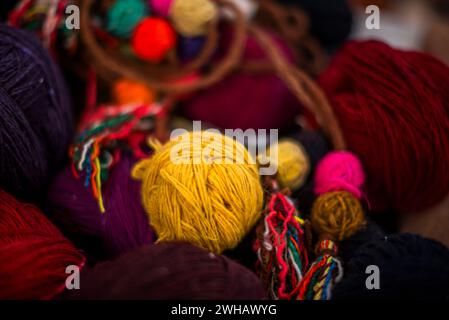 Primo piano di spiedini di lana di colore giallo rosso viola rosa arancio fili di lana di alpaca palle colorate di lana Vicuna pendenti di lana Inca in Perù Foto Stock