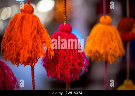 Primo piano di spiedini di lana di colore giallo rosso viola rosa arancio fili di lana di alpaca palle colorate di lana Vicuna pendenti di lana Inca in Perù Foto Stock