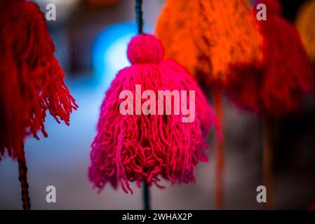 Primo piano di spiedini di lana di colore giallo rosso viola rosa arancio fili di lana di alpaca palle colorate di lana Vicuna pendenti di lana Inca in Perù Foto Stock