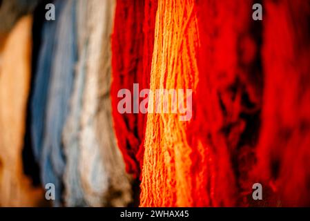 Primo piano di spiedini di lana di colore giallo rosso viola rosa arancio fili di lana di alpaca palle colorate di lana Vicuna pendenti di lana Inca in Perù Foto Stock