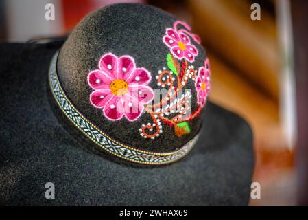 Primo piano di un cappello verde in feltro ricamato con copricapo giallo rosa arancio fucsia Alpaca e ricamo ad Arechipa in Perù Foto Stock