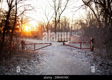 Una recinzione chiusa in legno su un sentiero sterrato che conduce ai boschi Foto Stock