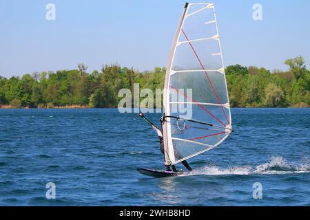 Ragazza di windsurf che mostra il cartello di saluto dei surfisti "shaka" (lago di Baden, Germania) Foto Stock