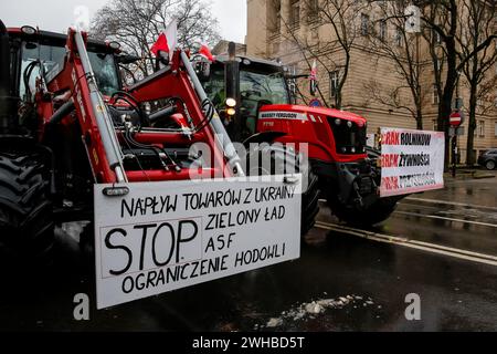 Poznan, Polonia, 9 febbraio 2024. Gli agricoltori della regione della grande Polonia nella Polonia occidentale guidano i loro trattori con striscioni anti il Green Deal mentre bloccano la strada Aleja Niepodleglosci nel centro di Poznań, la capitale della grande Polonia di fronte all'Ufficio Marshal durante lo sciopero degli agricoltori a livello nazionale. La protesta in Polonia fa parte della protesta degli agricoltori europei contro i regolamenti del Green Deal dell'UE. Gli agricoltori polacchi chiedono inoltre una modifica dell'accordo UE con l'Ucraina in merito all'importazione di prodotti agricoli nell'UE. La protesta a Poznań, la capitale della grande Polonia, Foto Stock