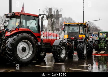 Poznan, Polonia, 9 febbraio 2024. Gli agricoltori della regione della grande Polonia nella Polonia occidentale guidano i loro trattori mentre bloccano la strada Aleja Niepodleglosci nel centro di Poznań, la capitale della grande Polonia di fronte al monumento della Twin Cross durante lo sciopero degli agricoltori a livello nazionale. La protesta in Polonia fa parte della protesta degli agricoltori europei contro i regolamenti del Green Deal dell'UE. Gli agricoltori polacchi chiedono inoltre una modifica dell'accordo UE con l'Ucraina in merito all'importazione di prodotti agricoli nell'UE. La protesta a Poznań, la capitale della grande Polonia, fu organizzata da Rola Wielkopolsk Foto Stock