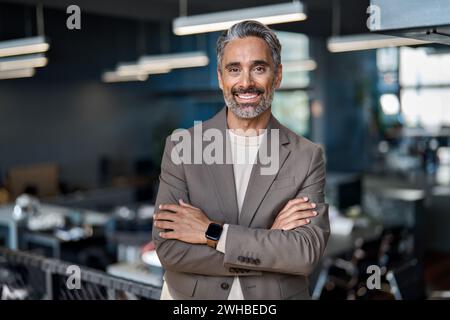 Un ceo di mezza età sorridente che guarda la fotocamera in ufficio, un ritratto. Foto Stock
