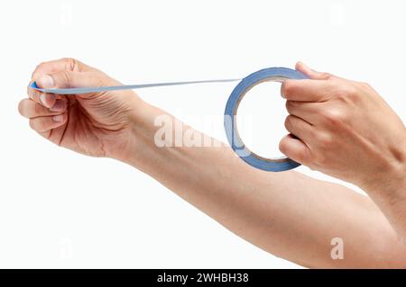 Foto ritagliata di un uomo irriconoscibile che tiene le mani e utilizza un nastro di mascheratura isolato su uno sfondo bianco Foto Stock