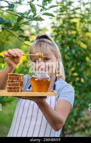 Una donna tiene il miele in giardino. Messa a fuoco selettiva. Foto Stock