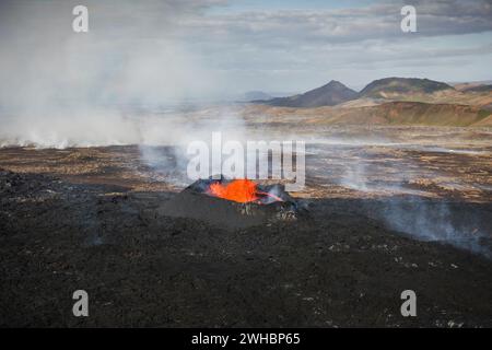 Scatto mozzafiato del momento drammatico di un'eruzione vulcanica, cratere sommitale con magma bollente, aereo direttamente sopra la vista. Potente concetto di forza della natura Foto Stock