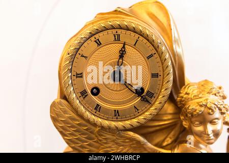 San Pietroburgo, Russia - 25 settembre 2022: Antico orologio di lusso con camino dorato e scultura d'angelo, foto ravvicinata. Orologio con Ro Foto Stock