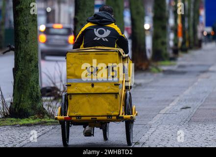 Berlino, Germania. 9 febbraio 2024. Un portacarte corre in bicicletta lungo una strada. Crediti: Monika Skolimowska/dpa/Alamy Live News Foto Stock