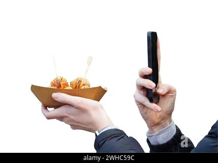 Le mani delle donne tengono il dessert e il telefono cellulare, la parte centrale del corpo delle donne si fanno selfie del dessert con spazio per le copie, il mercato del cibo di strada degli agricoltori isolato Foto Stock