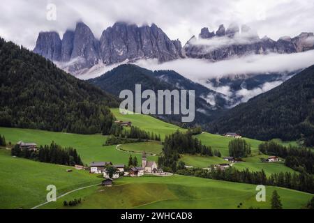 Chiesa di Santa Maddalena in Val di Funes, Dolomiti, Italia. Furchetta e Sass Rigais montagne sullo sfondo. Foto Stock