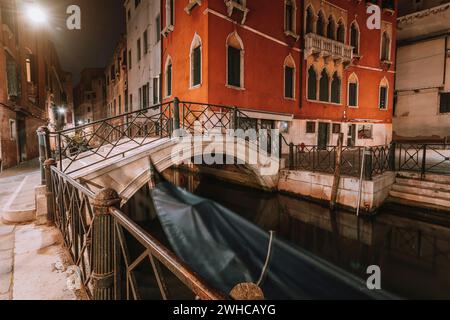 Piccolo canale e ponte ad arco nella città lagunare venezia di notte. Lunga esposizione Venezia Italia. Foto Stock