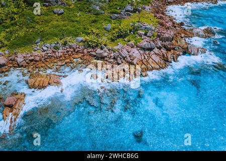 Foto aerea con drone della spiaggia segreta tropicale delle Seychelles Marron sull'isola di la Digue. Spiaggia di sabbia bianca con acque turchesi cristalline dell'oceano e rocce di granito. Foto Stock