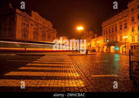 Piazza della città minore di Praga di notte con il tram in una lunga esposizione Foto Stock