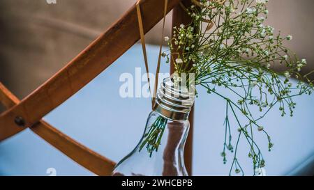 Nozze originali decorazioni floreali in forma di mini-vasi e i mazzi di fiori appesi dalla sedia Foto Stock