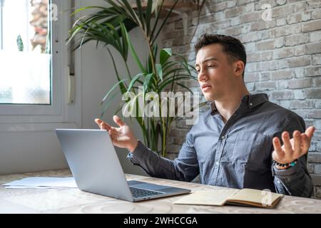 Infelice giovane lavoratore maschile caucasico in occhiali guardare lo schermo del laptop scioccato da guasto gadget o problemi operativi. Uomo frustrato confuso sorpreso da un errore imprevisto sul dispositivo del computer. Foto Stock