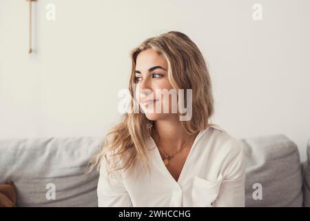 Giovane donna felice guardare a distanza sentirsi positiva e ottimista, sognare o visualizzare un nuovo inizio, sorridere ragazza millennial che pensa felicemente eccitata per il futuro, felicità, buon umore Foto Stock