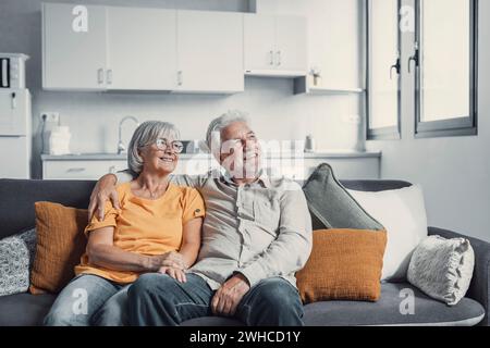 Sognare coppie di famiglie in pensione di mezza età che amano stare a distanza, progettando un futuro comune o rievocando ricordi, godendo momenti tranquilli di relax insieme su un comodo divano nel soggiorno Foto Stock