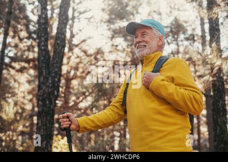 Ritratto, primo piano dell'uomo caucasico di mezza età che cammina e si gode la natura in mezzo agli alberi nella foresta. Vecchio uomo maturo che indossa occhiali da trekking e scoperta. Foto Stock