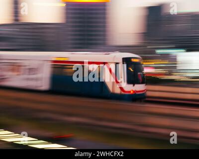 Treno sopraelevato in rapido movimento nella città di Bangkok, Thailandia. Paesaggio urbano dello skytrain BTS con effetto di sfocatura del movimento ad alta velocità. La corsa allo skytrain di Bangkok. El Foto Stock