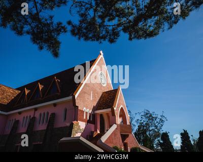 Domaine De Marie Church Diocesi sullo sfondo blu del cielo, nascosta dietro i rami di pini nelle giornate di sole, situata a da Lat, provincia di Lam Dong, Vietnam. Foto Stock