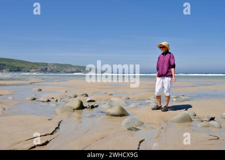 Donna sulla spiaggia con la bassa marea, baia Baie des Trepass, Cap Sizun, dipartimento Finistere, Bretagna, Francia Foto Stock