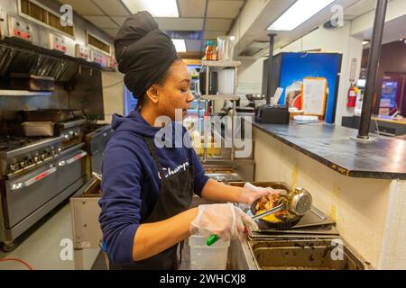 Detroit, Michigan - Natasha Coleman prepara cibo al ristorante Yum Village, che serve pasti afro-caraibici. Foto Stock