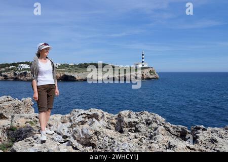 Donna e faro, Punta de ses Crestes, Porto Colom, Maiorca, Isole Baleari, Spagna Foto Stock