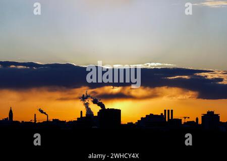 Pennacchi di fumo provenienti dai camini di una centrale combinata di calore ed energia e di una centrale di scarto-energia al tramonto, Berlino, 26/04/2021 Foto Stock